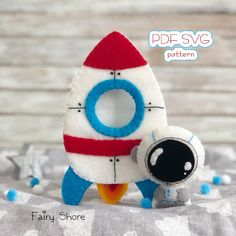 a small stuffed toy is next to a plush rocket ship