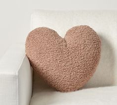 a heart shaped pillow sitting on top of a white couch