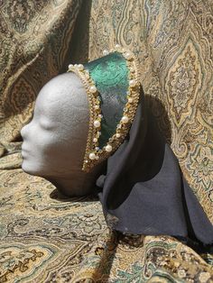 Ready made French Hood made from Jacquard in green with a beautiful sheen, decorated with a golden lace, a petite old gold lace, white acrylic pearls in two sizes and chrystal glass beads, which are all sewn on and not glued.  The Hood has a sewn in circlet and ties for you to make sure it stays on your head.  The base of this hood is an acrylic foil which stays in shape, even in rain and is very flexible. Comes with a black chiffon veil which is attached to the back. Ready made. Elegant Gold Cap Costume Headpiece, Elegant Gold Cap Costume Hat, Traditional Green Headpiece For Parties, Chiffon Veil, Green French, Golden Lace, Anne Boleyn, Black Chiffon, Gold Lace