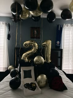 black and gold balloons are on the bed