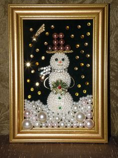 a snowman made out of pearls in a gold frame