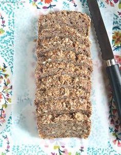 a loaf of bread sitting on top of a table next to a knife and flowered cloth