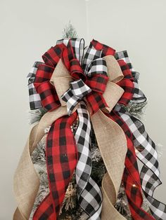 a christmas tree decorated with red, black and white buffalo plaid ribbon for the top