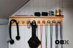 there are many different items hanging on the wall with hooks and cords attached to it