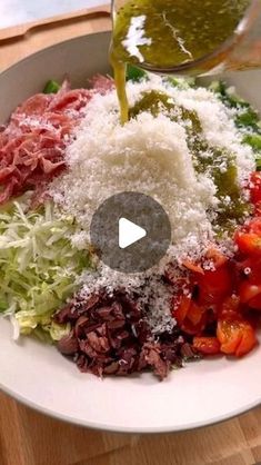 a white bowl filled with lots of different types of food on top of a wooden table