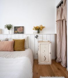 a bedroom with white walls and wooden floors