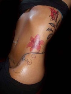 a woman's lower back tattoo with flowers on it