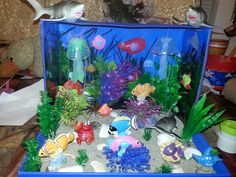 an aquarium filled with fish and plants on top of a table