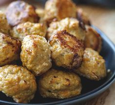 a blue bowl filled with meatballs on top of a wooden table