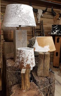 two lamps are on top of logs in a room with deer heads and other items