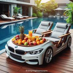 a white car with fruit in the trunk and chairs around it near a swimming pool