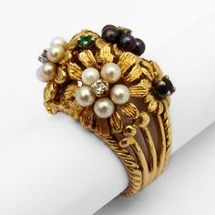 "Vintage 18 K (.750) yellow gold cocktail ring in floral designs, decorated with Seed Pearls, Emerald, Ruby, Sapphire and Diamonds. This fabulous ring is a size 7, 11/16\" wide and weighs 14.6 grams. EA1065" Yellow Gold Flower-shaped Multi-stone Rings, Yellow Gold Floral Multi-stone Rings, Yellow Gold Flower-shaped Rings With Multi-stone, Exquisite Gold Rings For Evening, Elegant Multi-stone Flower Ring, Elegant Multi-stone Gold Pearl Ring, Yellow Gold Flower Ring With 17 Jewels For Anniversary, Elegant Gold Cluster Ring With Flower Shape, Formal Multi-stone Yellow Gold Flower Ring