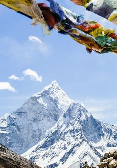 there is a mountain with many flags in the air and some rocks on the ground