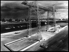 a black and white photo of a large crane on top of a building under construction