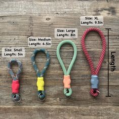 four lanyards with different colors and sizes are shown next to each other on a wooden surface