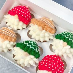 decorated cupcakes in a white box on a table