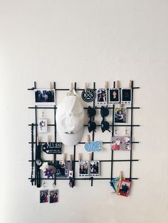 there is a white mask on the wall with many pictures and pins attached to it