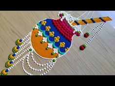 this is an image of a colorful kite made out of beads and thread on wood