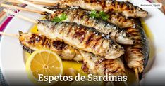 grilled fish on skewers with lemon and parsley garnishes