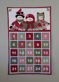 a calendar with two snowmen on it and numbers in red, green and white