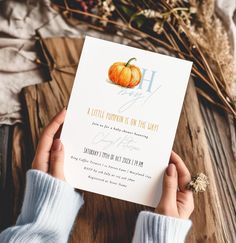 a person holding up a card with a pumpkin on it