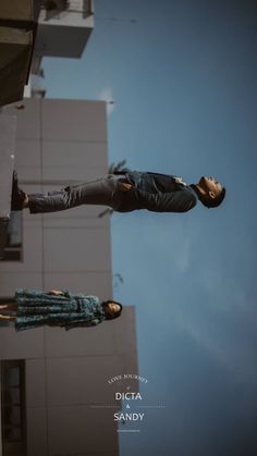 a man flying through the air while riding on top of a skateboard in front of a tall building