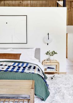 a bedroom with a bed, nightstands and pictures on the wall