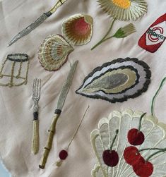 an embroidered table cloth with various items on it