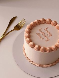 a birthday cake on a plate with a fork and knife next to it that says happy birthday