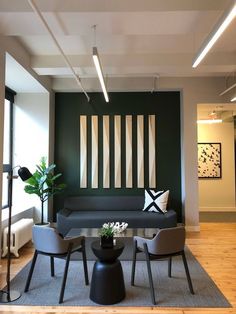 a living room filled with furniture next to a wall mounted art piece on the wall