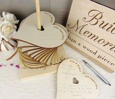 two wooden heart shaped boxes with writing on them and a pen next to one that says,'best mom in a wood box '