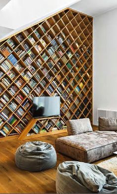 a living room filled with furniture and bookshelves next to a wall full of books