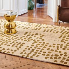 a living room area with a rug, chair and coffee table