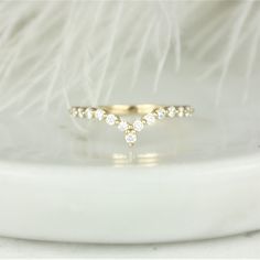 a gold ring with three small diamonds on the top and one smaller diamond in the middle