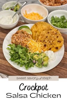 the crockpot salsa chicken is served on a white plate with lettuce, sour cream and cilantro