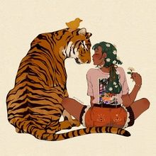 a woman sitting on the ground next to a tiger with flowers in her hair,