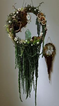 a clock hanging from the side of a wall next to a plant and other decorations