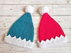 two crocheted hats sitting on top of a wooden floor