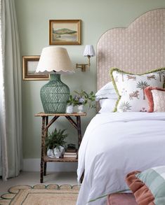 a bed room with a neatly made bed and two lamps