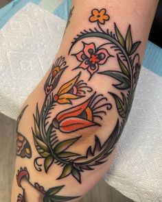 a tattoo with flowers and birds on it