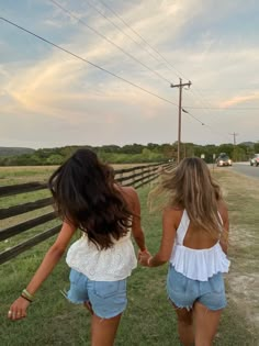 two girls walking down the road holding hands