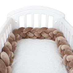 a white crib with a brown braid on it