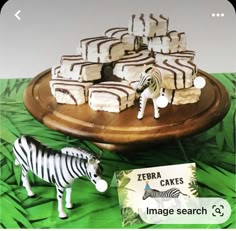 there is a cake with zebras on it and a toy zebra next to it