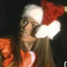 a woman wearing a santa hat and looking at the camera