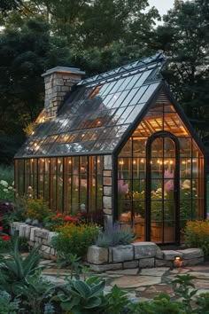 a small greenhouse in the middle of a garden with lights on it's roof