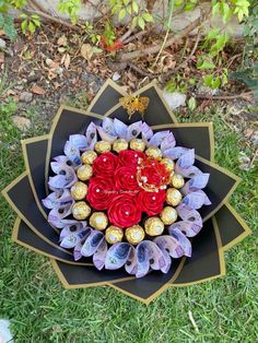 a bouquet of roses and chocolates in the shape of a heart on some grass