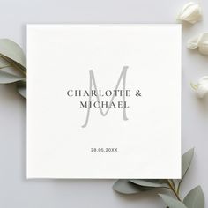 a white card with the word charlotte and michael on it next to some green leaves