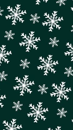 white snowflakes on a dark green background seamless wallpaper or fabric design