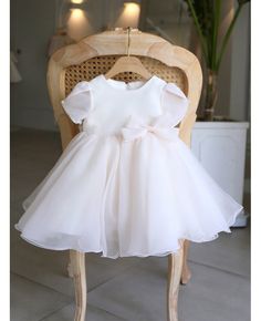 a white dress sitting on top of a wooden chair