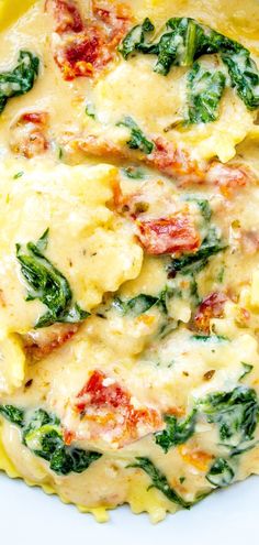 an omelet with spinach, cheese and tomatoes in it on a plate